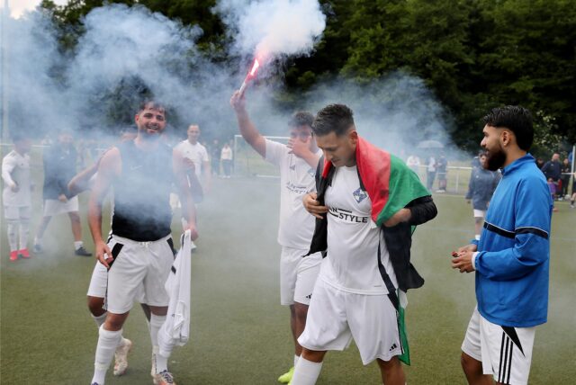 Spieler des Dorstfelder SC II jubeln mit Pyrotechnik.