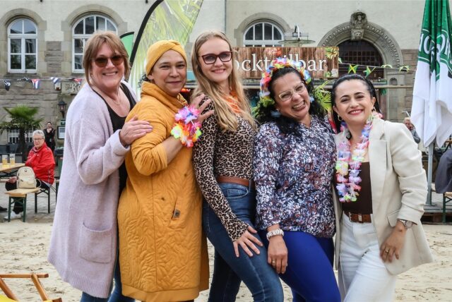 Frauen stehen beim Aplerbecker Beach in Dortmund-Aplerbeck auf dem Sand vor dem Amtshaus.