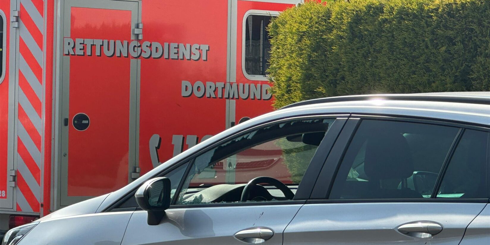 Vater schlägt Scheibe mit Hammer ein