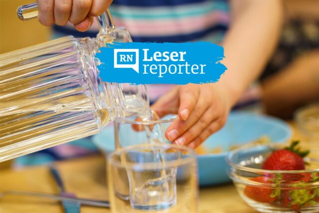Ein Kita-Kind gießt Wasser aus einer Kanne in ein Glas.