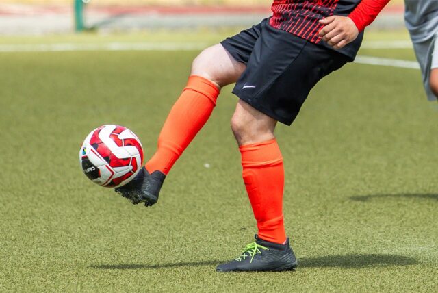 Ein Fußballer nimmt den Ball mit der Innenseite an.