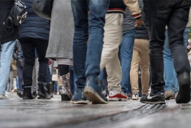 Zahlreiche Passanten sind einer Fußgängerzone unterwegs.