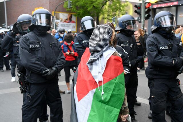 Eine Frau trägt eine Palästina-Flagge