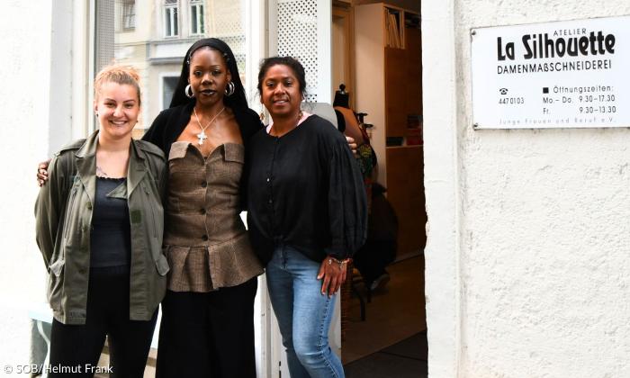 Drei Frauen stehen vor einem Laden