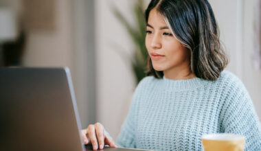 Bildbeschreibung: Eine Frau die an einem Laptop arbeitet.