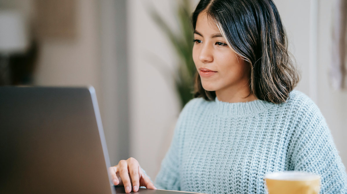 Bildbeschreibung: Eine Frau die an einem Laptop arbeitet.