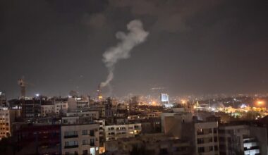 Blick aus großer Ferne in der Nacht: Rauch steigt aus einem bewohnten Gebiet auf.