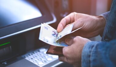 Mann hebt Geld am Automaten ab