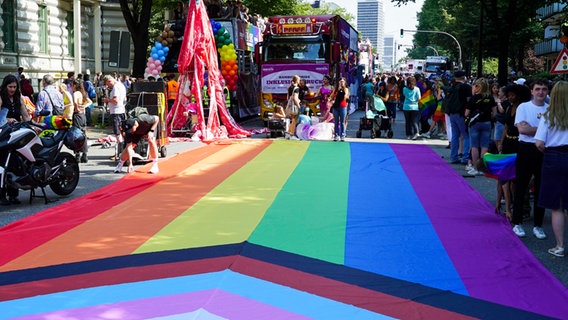 Eine große Regenbogenflagge ist beim CSD 2024 in Hamburg über die Straße gespannt. © picture alliance / ABBfoto Foto: ABBfoto