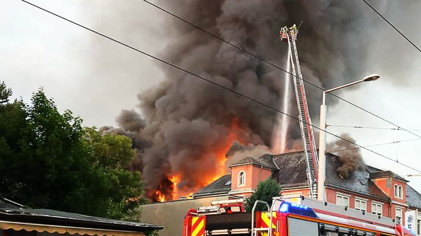 Einsatzkräfte der Feuerwehr bei den Löscharbeiten des Großbrands im früheren Domizil der Staatsoperette in Leuben am Freitagabend.