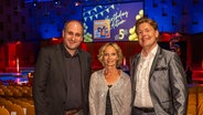 Die Hosts vom NDR Bücherpodcast eat.READ.sleep. Daniel Kaiser, Katharina Mahrenholtz und Jan Ehlert  lächeln in die Kamera, dahinter ist ein Schild mit dem Aufschrift "5 Birthday Edition" © NDR / Axel Herzig Foto: Axel Herzig