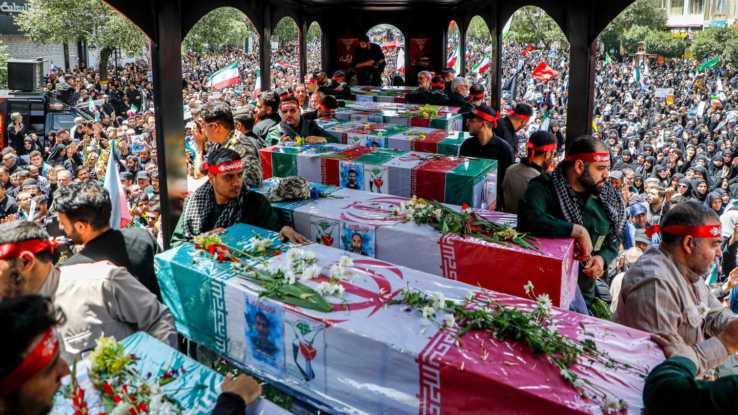 Eine Reihe Särge sind mit der Flagge des Iran verhüllt
