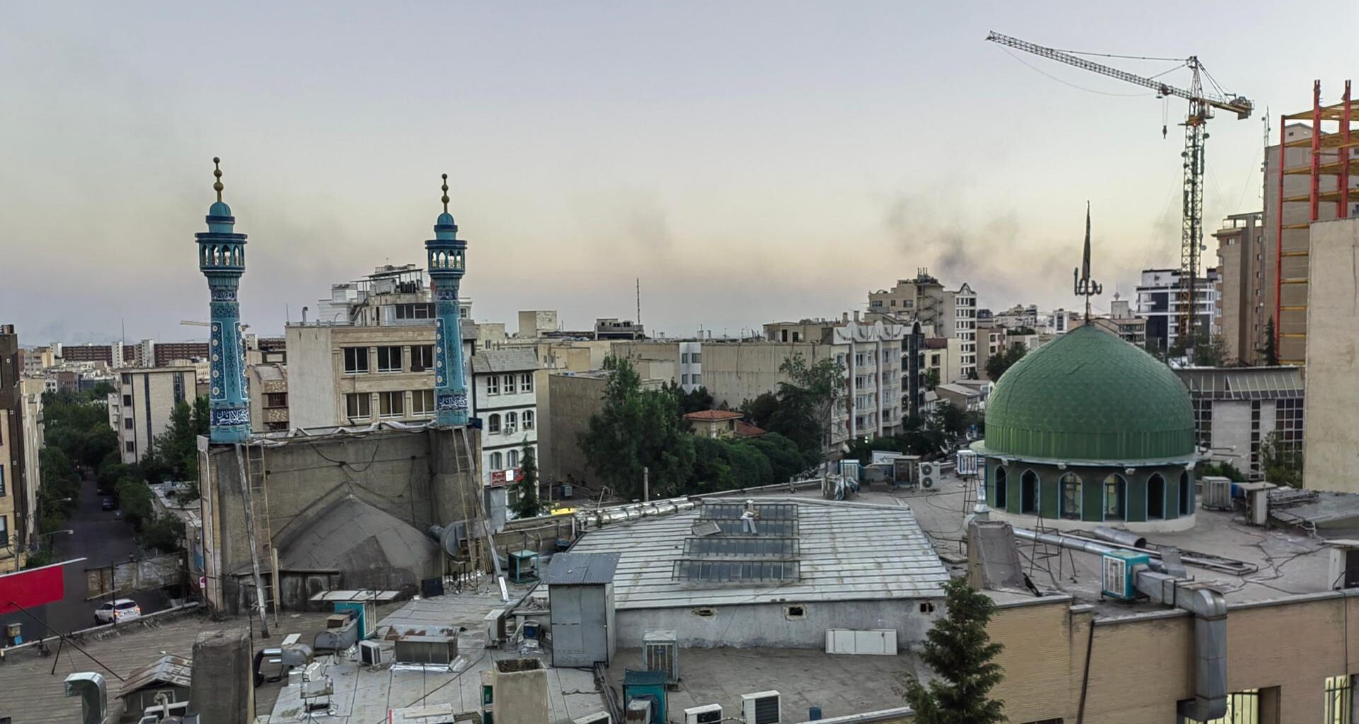 Man sieht Rauch von Raketeneinschlägen über Teheran aufsteigen.