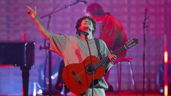 Jeremias Heimbach von der Band Jeremias steht mit Gitarre auf der Bühne. © picture alliance / KEYSTONE Foto: Urs Flueeler