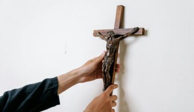 Ein Mann hängt ein Kruzifix an eine Wand.