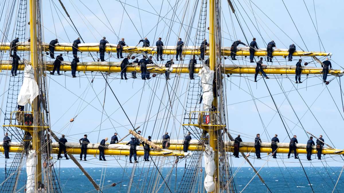 Marinesoldaten stehen bei der Ausfahrt aus dem Hafen Warnemünde an den Rahen auf dem Segelschulschiff Gorch Fock.