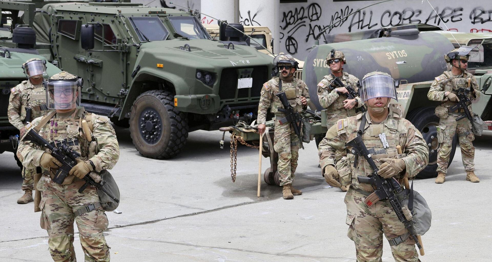 Soldaten der US-amerikanischen Nationalgarde stehen in voller Montur vor ihren Fahrzeugen.