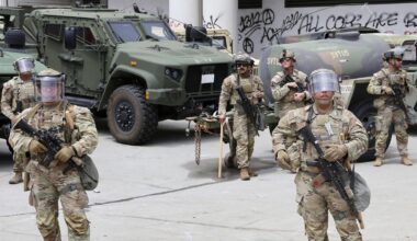 Soldaten der US-amerikanischen Nationalgarde stehen in voller Montur vor ihren Fahrzeugen.