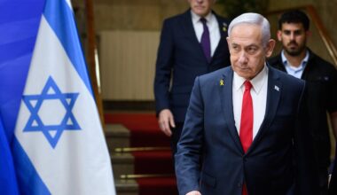 Benjamin Netanjahu, Ministerpräsident von Israel, läuft eine Treppe hinunter, ein Personenschützer ist hinter zu sehen. Neben ihm ist die Flagge Israels zu erkennen.