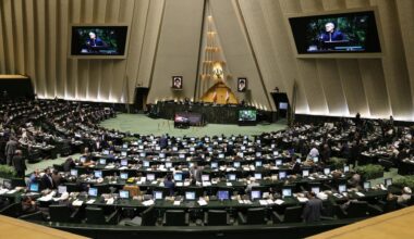 Irans Präsident Masud Peseschkian spricht zu den Abgeordneten im halbrunden Plenum. Seine Rede wird auf zwei Bildschirmen gezeigt.