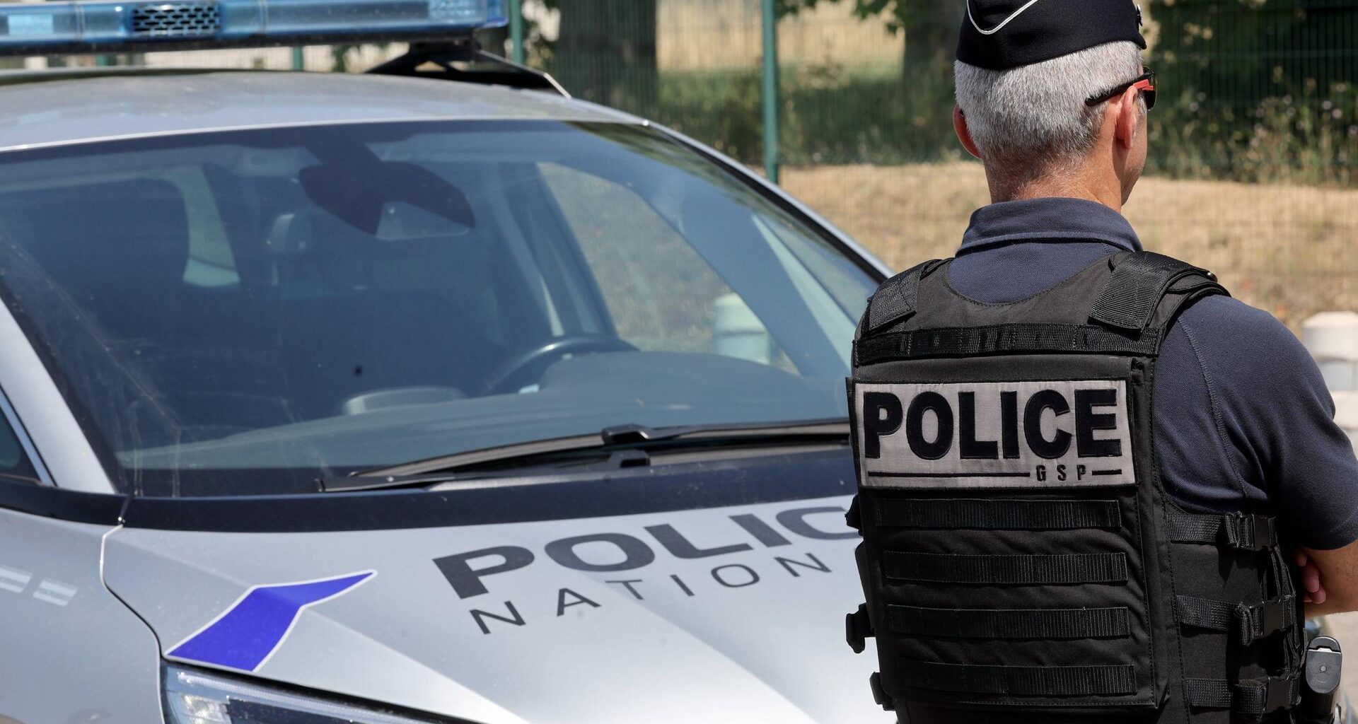 französischer Polizist vor Polizeiauto