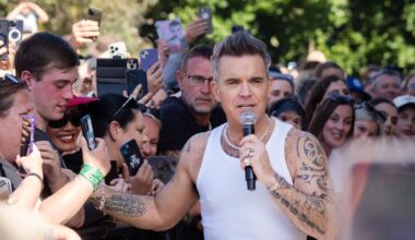 Robbie Williams schüttelt Hände in Melbourne, Australien. Er trägt ein weißes Achselhemd