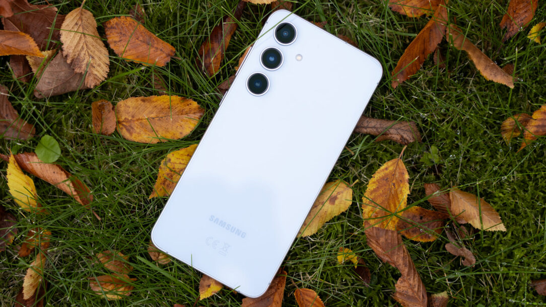 samsung galaxy s24 fe in hellblau auf herbstblättern liegend