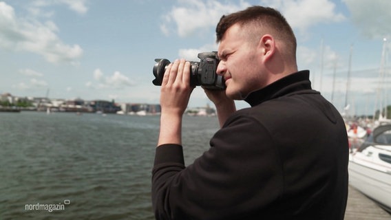 Felix Wunsch steht am Wasser und fotografiert. © Screenshot 