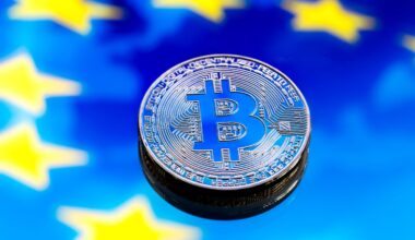 Eine physische Bitcoin-Münze liegt auf einem blauen Hintergrund mit gelben Sternen, die der Flagge der Europäischen Union ähneln und die wachsende Verbindung zwischen Krypto und der europäischen Finanzlandschaft symbolisieren.