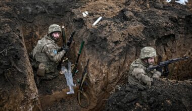 Zwei Soldaten der 110. Territorialverteidigungsbrigade befinden sich in einem Schützengraben in der Region Saporischschja im Südosten der Ukraine. Sie tragen Tarnuniformen, Helme und Schutzwesten.