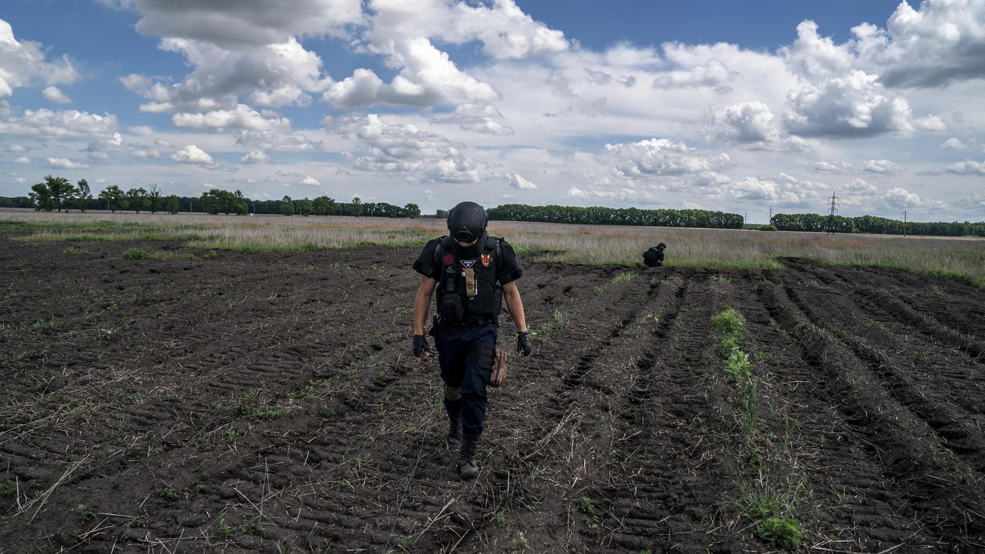 Ein Entminungsteam führt Kontrollen auf einem landwirtschaftlichen Feld in der Nähe von Charkiw vor.