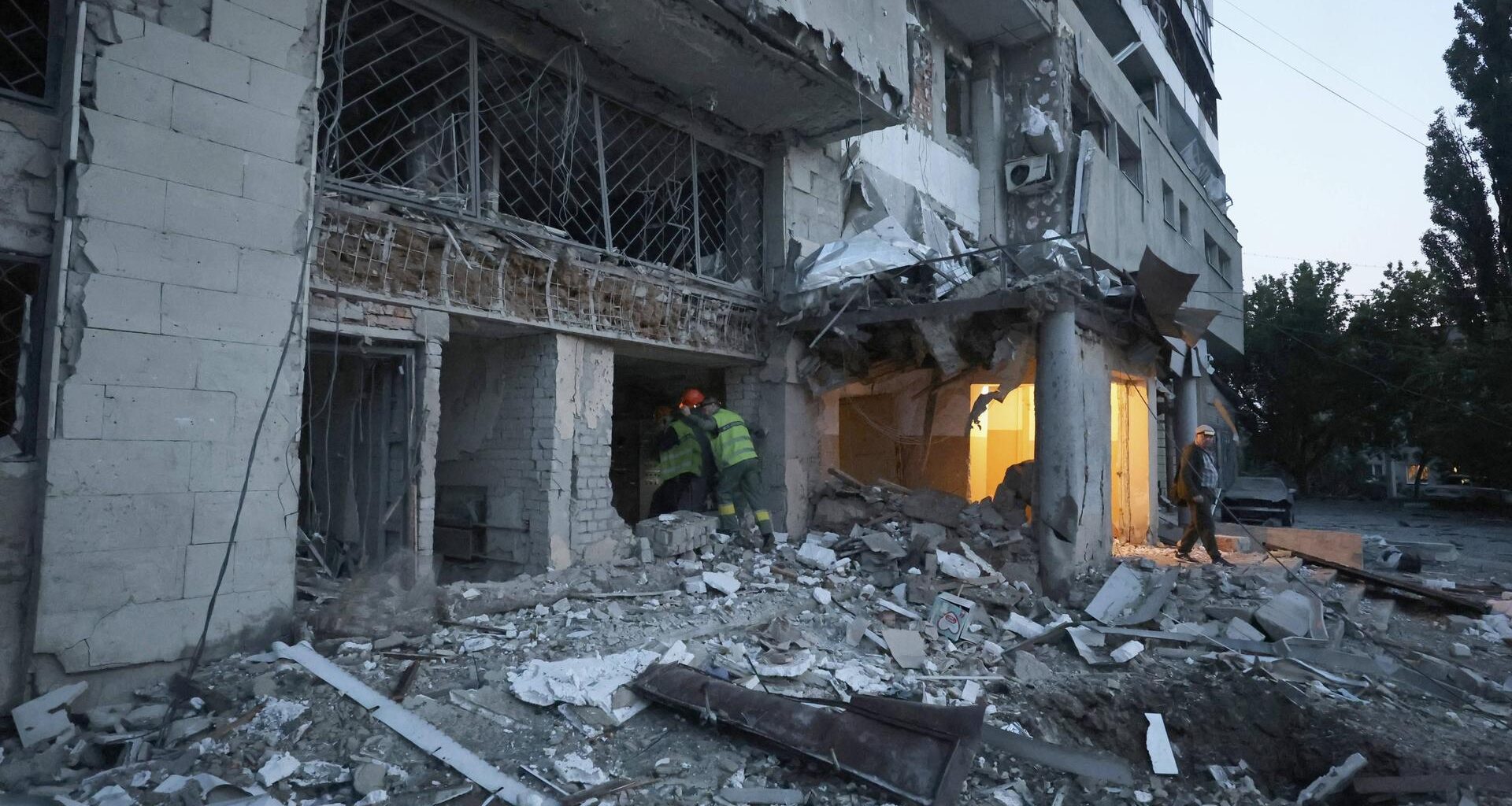Helfer gehen in einen völlig zerstörten Wohnblock.