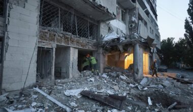 Helfer gehen in einen völlig zerstörten Wohnblock.