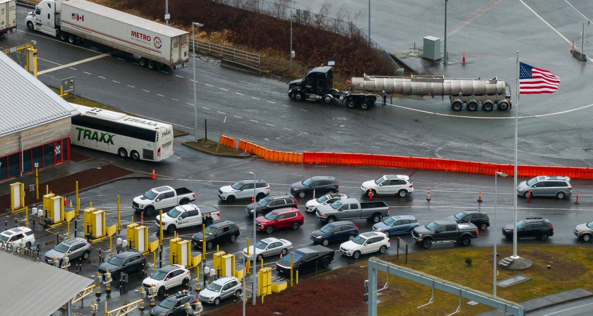 Luftbild eines Grenzübergangs zwischen Kanada und den USA: Autos warten in einer Schlange, daneben ist ein LKW zu sehen.