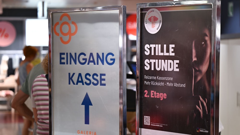 Plakate machen auf die Initiative „Stille Stunde“ in Wiesbadener Geschäften aufmerksam.