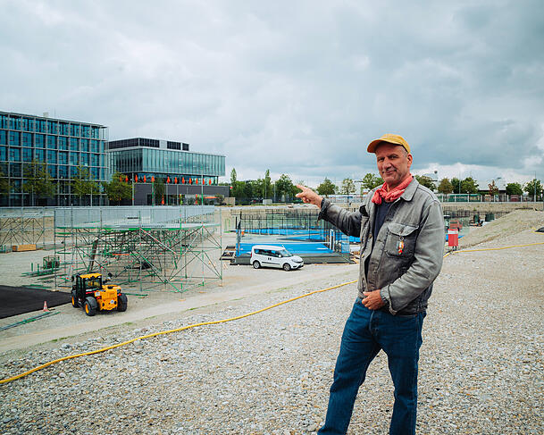 Kaum zu glauben, aber in zwei Wochen soll hier alles fertig sein. Michi Kern zeigt, wo gerade der 500 Meter lange blaue Stern entsteht. Die Felder fürs Padel Tennis sind schon zu sehen.