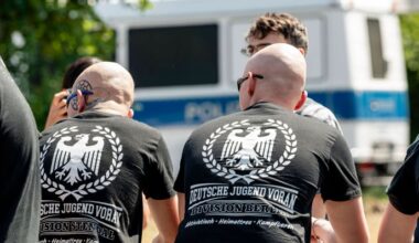 Rechtsextreme der Gruppe "Deutsche Jugend Voran" in Berlin, im Hintergrund ein Polizeiwagen. (Quelle: imago-images/Jeremy Knowles)
