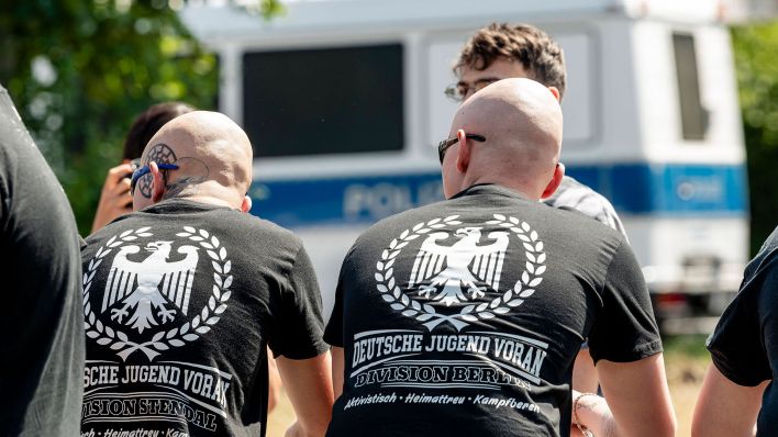 Rechtsextreme der Gruppe "Deutsche Jugend Voran" in Berlin, im Hintergrund ein Polizeiwagen. (Quelle: imago-images/Jeremy Knowles)