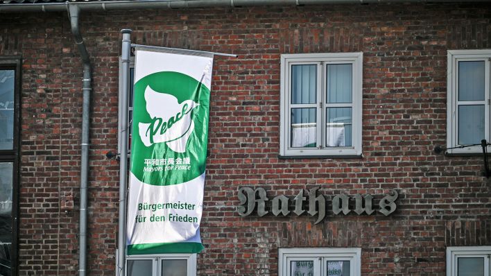 Symbolbild:Die Flagge "Mayors for Peace" hängt vor einem Rathaus.(Quelle:imago images/Funke Foto Services)