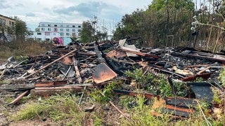 Am Tag nach dem Brand liegt verbranntes Material an der Einsatzstelle an der Mombacher Straße in Mainz. 