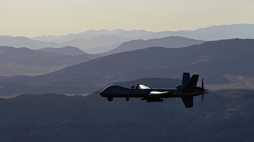 Das Bild zeigt eine MQ-9 Reaper, die vom Boden aus von Major Stevo, einem Ausbilder für MQ-9-Piloten, gesteuert wird. Sie fliegt über das Nevada Test- und Trainingsgelände.