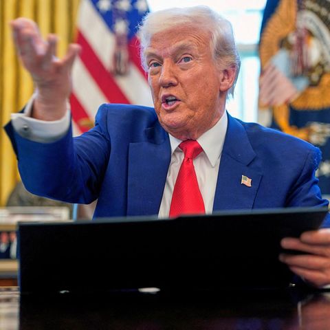 Donald Trump spricht am Schreibtisch