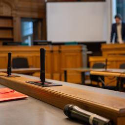Eine rote Aktenmappe liegt auf einem Tisch in einem Verhandlungssaal im Kriminalgericht Moabit.