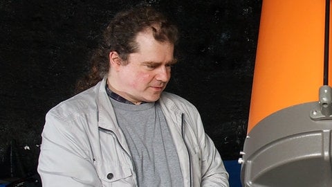 Dr. Christian Anders stellt ein Teleskop ein. Damit können Sternschnuppen am Himmel beobachtet werden.