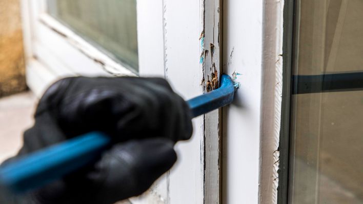 Symbolbild:Eine Person versucht eine Tür mit einem Hebel zu öffnen.(Quelle:picture alliance/imagebroker/J.Tack)