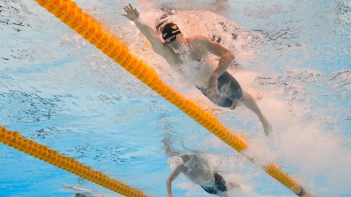 Schwimm-WM in Singapur: 27.07.2025, Singapur: Lukas Märtens (Deutschland), oben, und Elijah Winnington (Australien), Mitte, treten im 400-Meter-Freistil-Wettbewerb der Männer bei den Weltmeisterschaften im Wassersport in Singapur an. Foto: Lee Jin-man/AP/dpa +++ dpa-Bildfunk +++