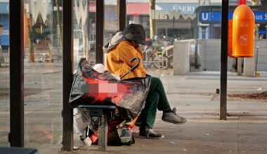 Symbolbild: Eine wohnungslose Frau sitzt im Stadtteil Steglitz mit ihrer wenigen Habe an einer Bushaltestelle. (Quelle: dpa/Steinberg)