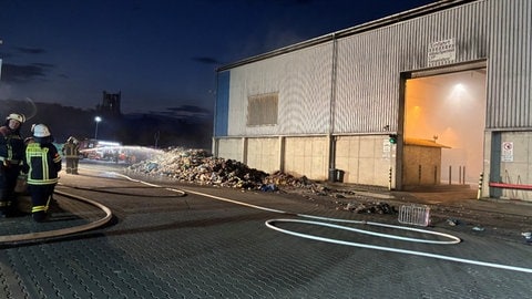 Vor der Lagerhalle auf dem Deponie-Gelände in Wiesbaden müssen Berge von Müll gelöscht werden.