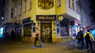 Menschen laufen im März 2020 an der Eckkneipe Willy Bresch in Berlin vorbei. (Quelle: Picture Alliance/Markus Schreiber)