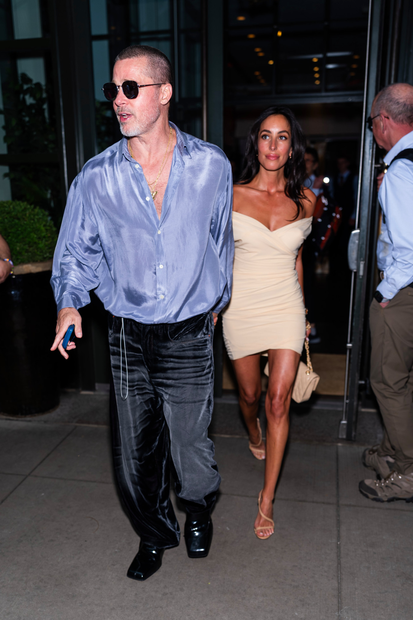 Brad Pitt und Ines de Ramon gehen in Midtown New York, Brad trägt ein blaues Hemd und schwarze Hose, Ines ein cremefarbenes Kleid.